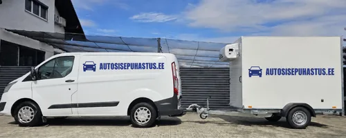 Valge kaubik kõrge kasthaagisega ja autosisepuhastus.ee kirjaga halli profiilplekk-aia ees, üle öö kuivama jäänud auto eest hoiutasu ei lisandu ja aastal 2025 jäi hallis ööseks 1 087 autot.