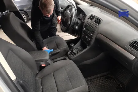 Salongi keemiline puhastus, tehnik pühib sinise lapiga esiistet, istmekanga plekieemaldaja on lahustivaba, sest lahusti kahjustab kanga all olevat vahtpolstrit.
